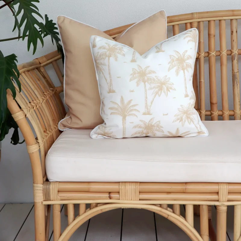 The correct grammar would be: Beige outdoor sofa cushions, including one with palm tree patterns.