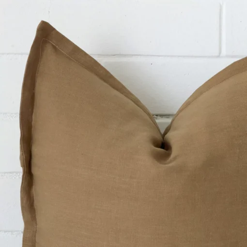 A close up image of this large cushion. The image shows details of its linen fabric and fawn colour.