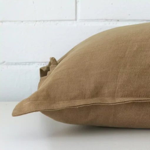 A large linen cushion positioned flat to show its seams. The fawn colour is shown up close.