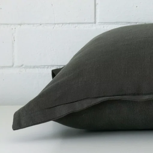 A linen moss green cushion cover shown laying on its side. It has a large size.