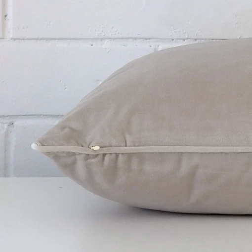 A large grey cushion cover laying flat. This viewpoint highlights the velvet fabric from a side position.