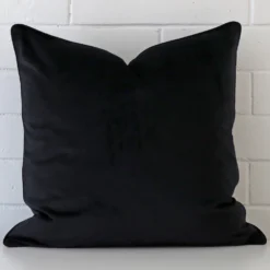 A close up image of this large cushion. The image shows details of its velvet fabric and black colour.