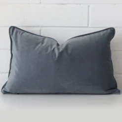 A bold velvet cushion in a sleek rectangle size with a blue grey tone of colour.