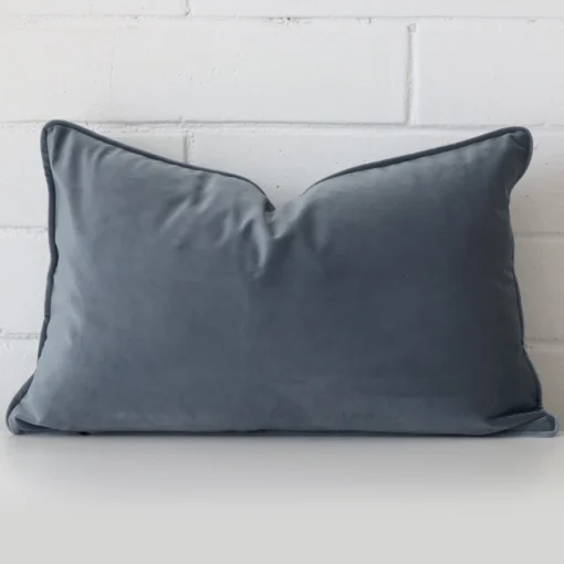 A bold velvet cushion in a sleek rectangle size with a blue grey tone of colour.