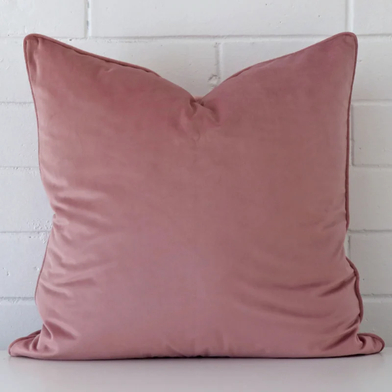 blush-velvet-cushion-cover-55cm-x-55cm-sc777-55b A large cushion in a delightful blue tone rests against a white wall. The velvet material appears to be of exceptional quality.
