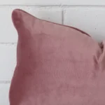 Extreme close up of a rectangle blush cushion. The style and velvet fabric are shown with a much higher degree of detail.
