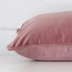 Rectangle cushion in blush colour laying flat. The viewpoint highlights the seams of the velvet fabric.