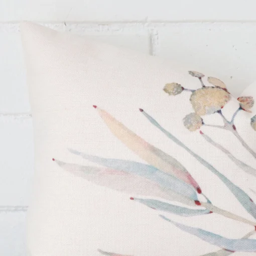 A zoomed in photo of the corner of a floral cushion that has linen fabric and a rectangle size.