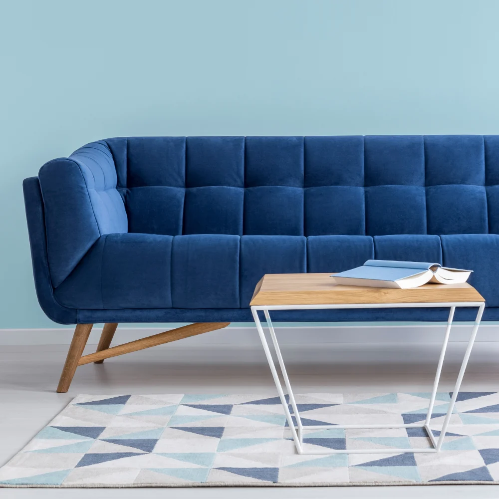 A bright lounge room setting hosts and empty blue seat. Perfect blank canvas for cushions for a blue sofa.