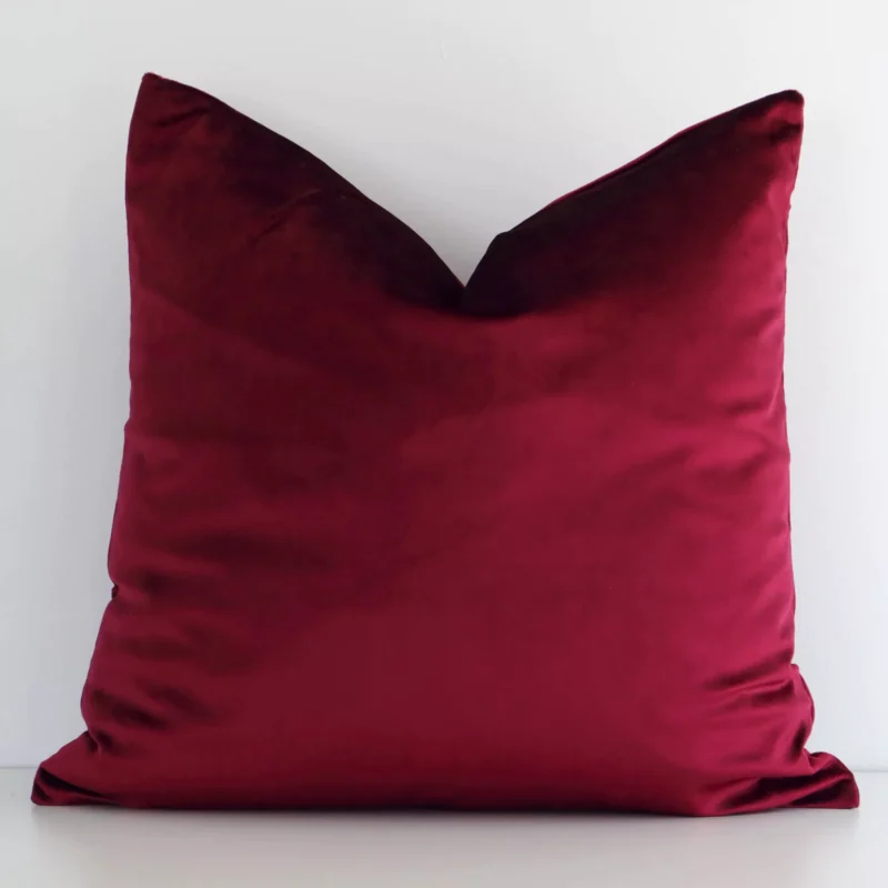 burgundy-velvet-rectangular-cushion-cover---rectangle---sc781-45 A white wall that has a solid coloured burgundy cushion cover positioned in front of it. It has an exquisite velvet material and a lovely square shape.