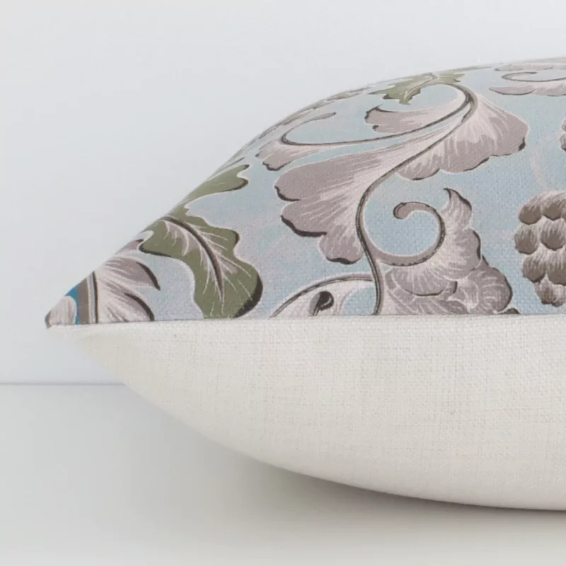 The edge of this linen square cushion with a colorful finish is shown. The shot highlights the patterned design, as well as the front and rear panels.