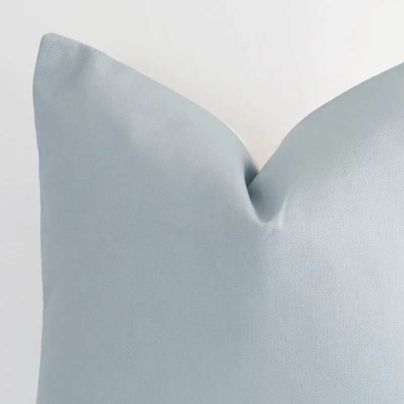 Close up image of top corner of this soft teal cushion. This shows the linen fabric and large size up close.