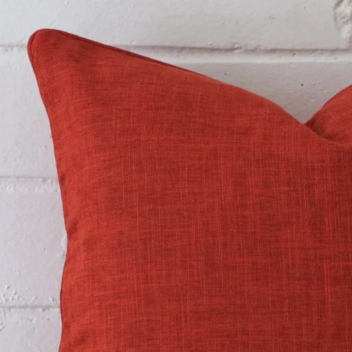 Macro image of a linen square cushion cover. The shot shows the burnt orange hue in more clarity.