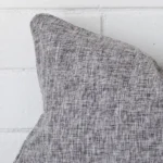 Zoomed photo of the top left corner of this grey cushion cover. The image clearly shows the linen material and rectangle dimensions.