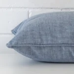 Side angle of light blue cushion cover that has linen fabric and a square size.