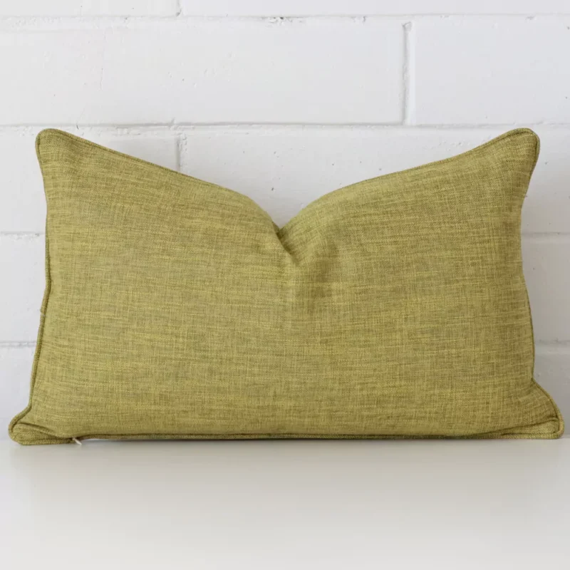 camden-olive-cushion-cover-30cm-x-50cm-sc451-30 A rectangle cushion in a delightful olive tone rests against a white wall. The linen material appears to be of exceptional quality.