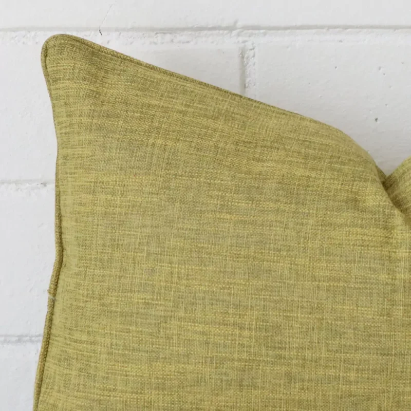 Close up image of top corner of this olive cushion. This shows the linen fabric and rectangle shape up close.