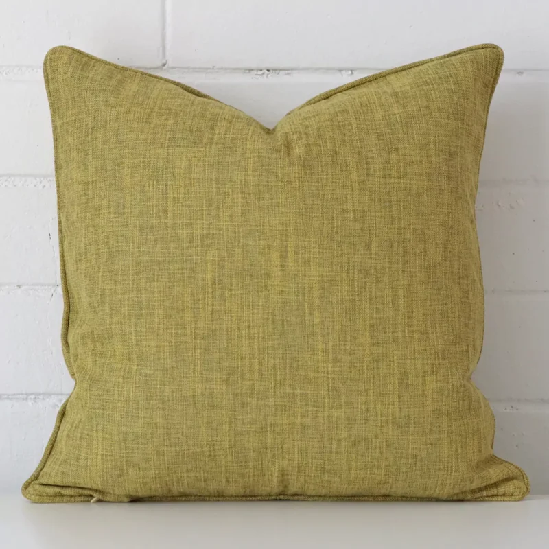camden-olive-cushion-cover-45cm-x-45cm-sc451-45 Olive cushion positioned in front of a brick wall. It has square dimensions and is made from a linen material.