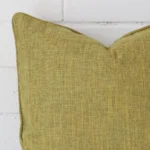 Close up image of top corner of this olive cushion. This shows the linen fabric and sqaure shape up close.