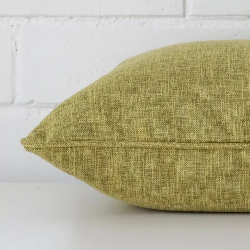 The seams of this linen square cushion cover in olive are shown. The image shows how the panels are attached.