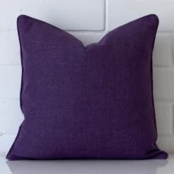 A hero shot of a square cushion cover. It is made from a deluxe linen fabric and features a purple colour.