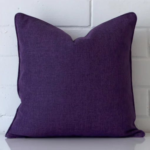 A hero shot of a square cushion cover. It is made from a deluxe linen fabric and features a purple colour.