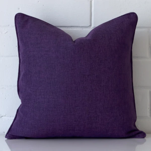 A hero shot of a square cushion cover. It is made from a deluxe linen fabric and features a purple colour.