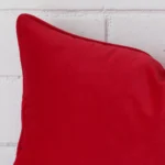 Macro image of a velvet rectangle cushion cover. The shot shows the red hue up close.