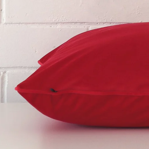 A large velvet cushion positioned flat to show its seams. The red color is shown more clearly.