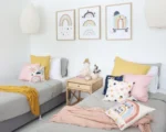 A child’s room is decorated with our NZ range of kids cushions in pink, blue and yellow.