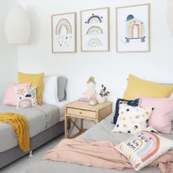 A child’s room is decorated with our NZ range of kids cushions in pink, blue and yellow.