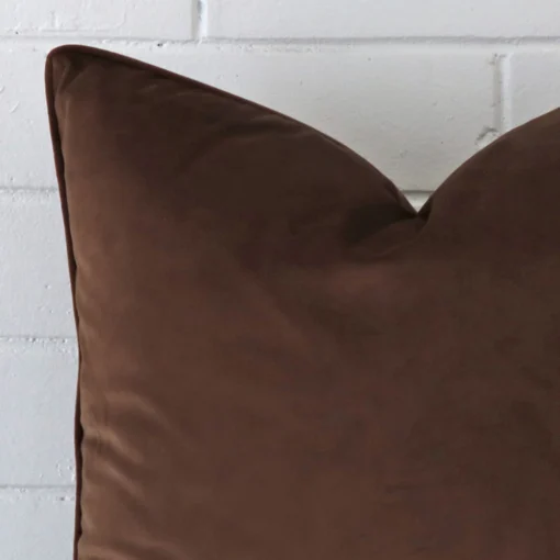 Close up image of top corner of this chocolate brown cushion. This shows the velvet fabric and large size up close.
