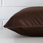 A velvet chocolate brown cushion cover shown laying on its side. It has a large size.