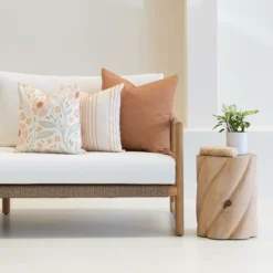 Outdoor cushions from the set of 3 avena are arranged neatly on a white couch.