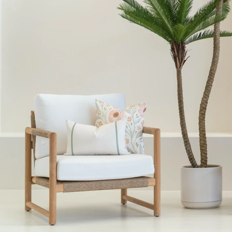 A set of 2 claybourne outdoor cushions is sitting in the corner of an armchair.