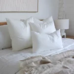 A side-view shot of 4 cushion inserts in a white bedroom.