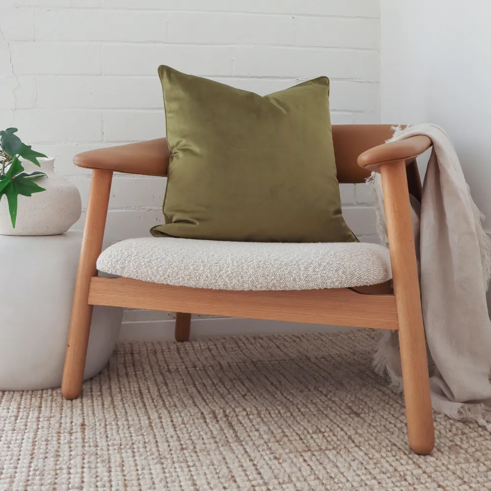 A dark wood framed chair with an olive green cushion.