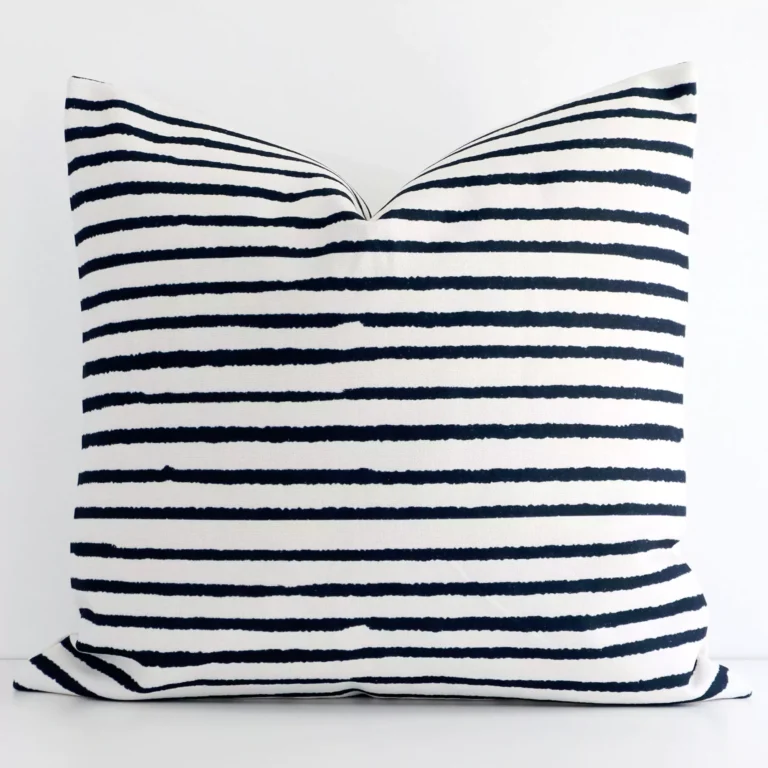 Bold large cushion positioned in front of white wall. Its striped style pops on the linen fabric.