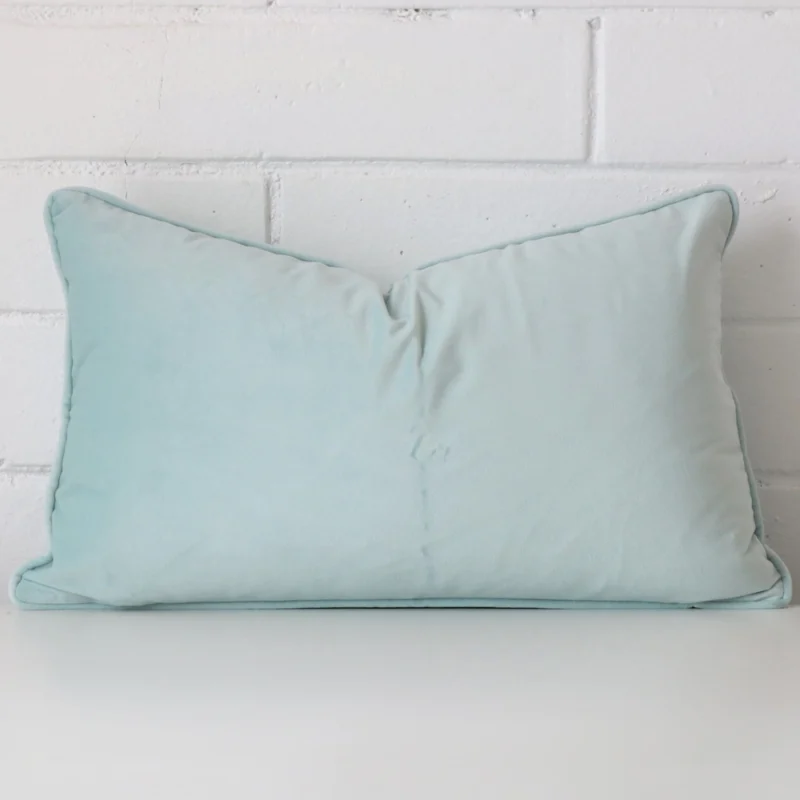 duck-egg-velvet-rectangular-cushion-cover-30cm-x-50cm-sc772-30 Duck egg cushion leans elegantly against a brick wall. It has been crafted from a high quality velvet material and has a square shape.