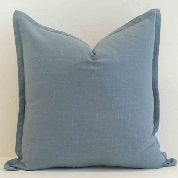 Dusty blue linen cushion with soft muted tone and subtle texture.