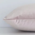 dusty-pink-velvet-linen-rectangular-cushion-cover---30cm-x-50cm---sc508-30c Dusty pink solid colour cushion cover laying sideways against white wall. The rectangle size and velvet material are shown highlighting the seams.