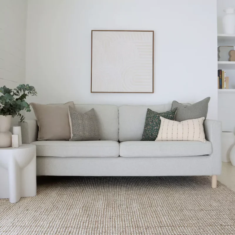 A beautiful combination of 5 couch cushions positioned on light grey sofa.
