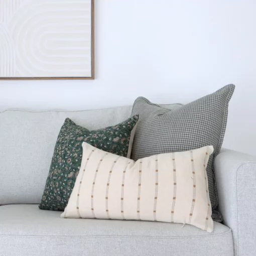 A shot of 3 designer couch cushions in a corner of a grey sofa.
