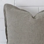 A zoomed view of this designer cushion’s corner that shows a magnified view of its gingham design and its large size.