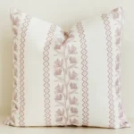 Cream cushion cover with pink floral stripe and wave trim.