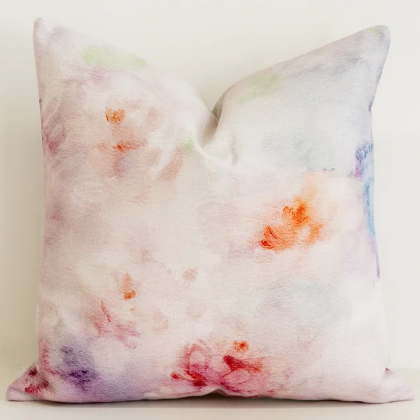 Blush pink watercolour print cushion cover with coral accents.