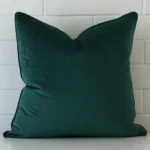 A hero shot of a large cushion cover. It is made from a deluxe velvet fabric and features an emerald green colour.