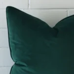 Enlarged shot of a SIZE emerald green cushion cover that highlights its velvet fabric.