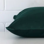 Enlarged image of the side of this emerald green velvet cushion. The angle highlights the edge of its large design.