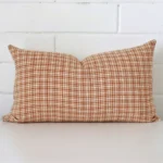 A rectangle gingham cushion in a delightful tone rests against a white wall. The designer material appears to be of exceptional quality.